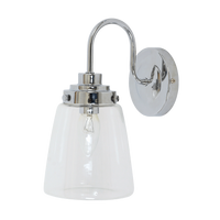 Tayne modern chrome wall light with curved arm and cylindrical clear glass shade mounted on a wall.